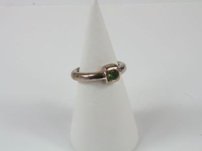 a close up of a ring with a green stone on it