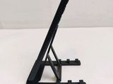 a black tablet computer sitting on a stand on a white surface