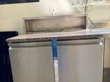 a stainless steel refrigerator in a kitchen with a chalkboard on the wall