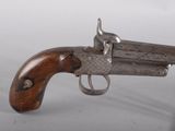 an old gun with a wooden handle on a white surface