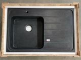 black kitchen sink in a wooden box on a concrete floor