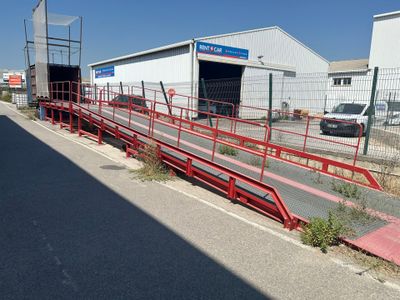 une rampe rouge à côté d'un immeuble, au bord de la route