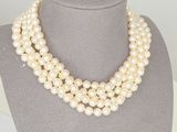 a white pearl necklace on a mannequin with a gold clasp