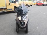 une moto garée sur un parking, avec un camion en arrière-plan