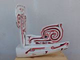 une sculpture en bois représentant un bateau, posée sur un socle en bois