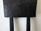 a black chair sitting against a white wall in a room