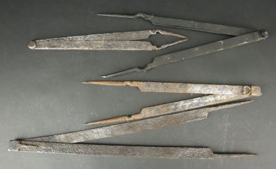 four old metal tools sitting on top of a table