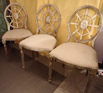 trois chaises à roulettes sont alignées contre un rideau jaune