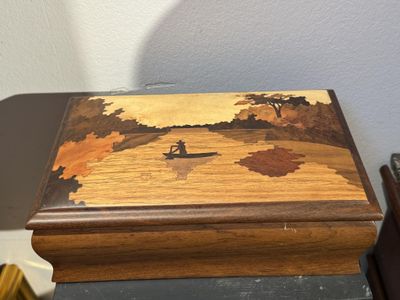 une boîte en bois sur laquelle est peinte une barque