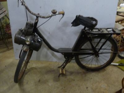 un vélo noir garé dans un garage, avec un sac à l'arrière