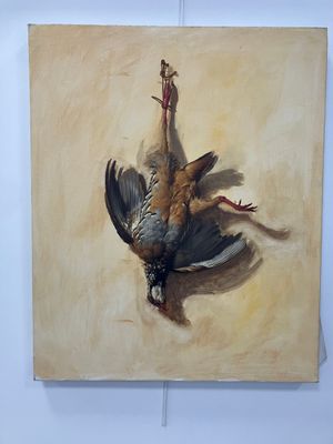 un tableau représentant un oiseau mort accroché à un mur