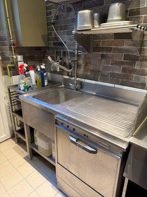 un évier en inox dans une cuisine, à côté d'un lave-vaisselle