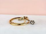 a pair of gold rings with diamonds on a marble surface