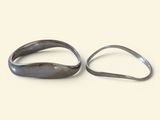 pair of silver rings sitting on top of each other on a white surface