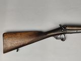an old rifle with a wooden handle on a white surface