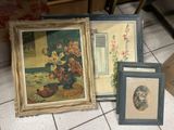 three framed pictures on the floor next to a vase of flowers