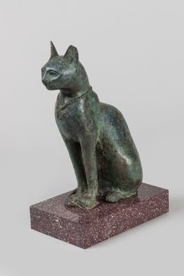 statue d'un chat assis sur un socle, sur fond blanc