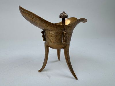 un brûle-parfum ancien en laiton surmonté d'un oiseau