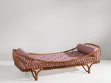 une photo d'une chaise longue en osier avec un coussin rose
