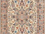 un tapis beige et bleu orné d'un motif en médaillon