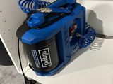a blue spray gun sitting on a shelf in a room
