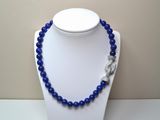 collier composé de perles bleues et muni d'un fermoir en argent, porté par un mannequin blanc