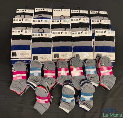 several pairs of men ' s socks are stacked on a black surface