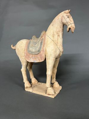 une vieille statue représentant un cheval avec une selle sur le dos