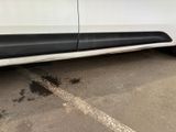 a white van with black trim parked in a parking lot