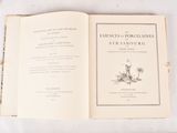 an open book on a table with a flower on it