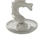 a glass figurine of a sea horse on a plate