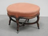 une image représentant un petit tabouret sur lequel est posé un coussin rose