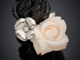 bague ornée d'une rose en noir et blanc, rehaussée de touches argentées sur un fond noir