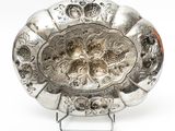 a silver plate on a stand on a white background