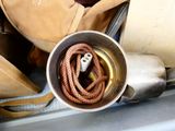 a metal cup with a rope in it on a table