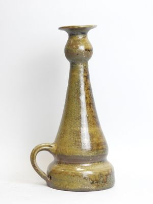 a brown vase that is sitting on a white surface