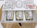 three candles in a box on a table with a map on it