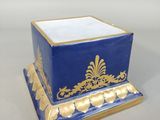 a blue and gold box with a gold decoration on it