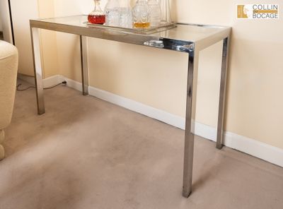 une table en verre sur laquelle sont posées des bouteilles, dans un salon