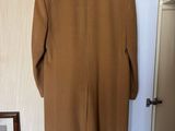 a brown coat hanging on a hanger in front of a mirror