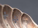 a close up of a silver spoon with holes in it