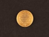 a close up of a gold coin on a black surface