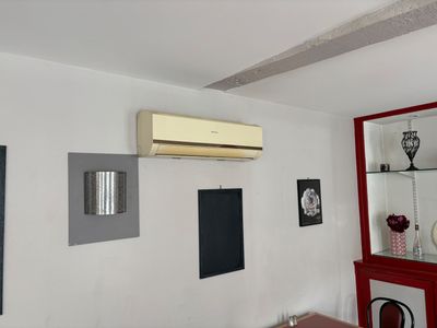 une photo d'un salon avec un climatiseur accroché au mur