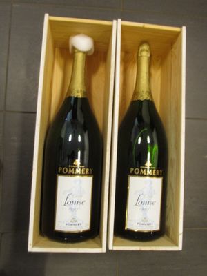 deux bouteilles de champagne dans un coffret en bois posé sur un sol carrelé