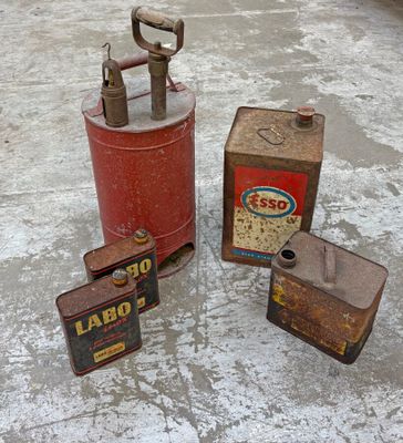trois vieilles bonbonnes de gaz posées sur un sol en béton