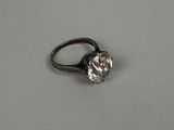 a close up of a diamond ring on a white surface