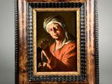 an old painting of a woman holding a pipe in a wooden frame
