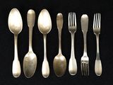 five spoons and a fork on a black table