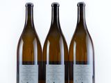 three bottles of wine sitting next to each other on a white surface