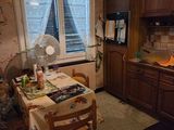 a kitchen with a table and a fan in it